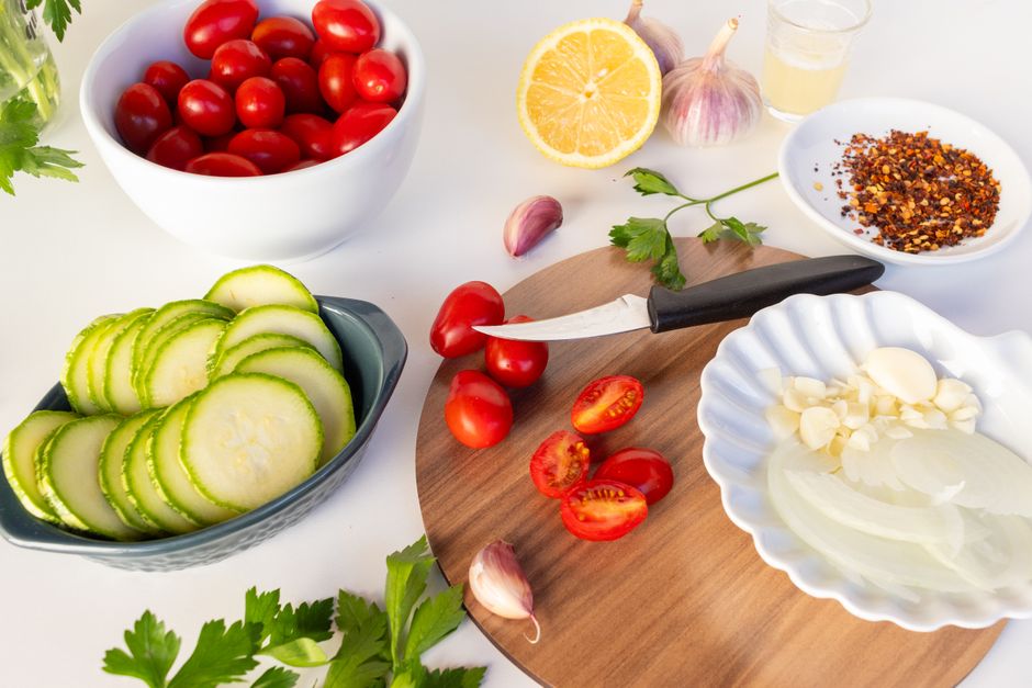 Vibrant ingredients including tomatoes, cucumbers, garlic, and spices prepared for a summer salad.